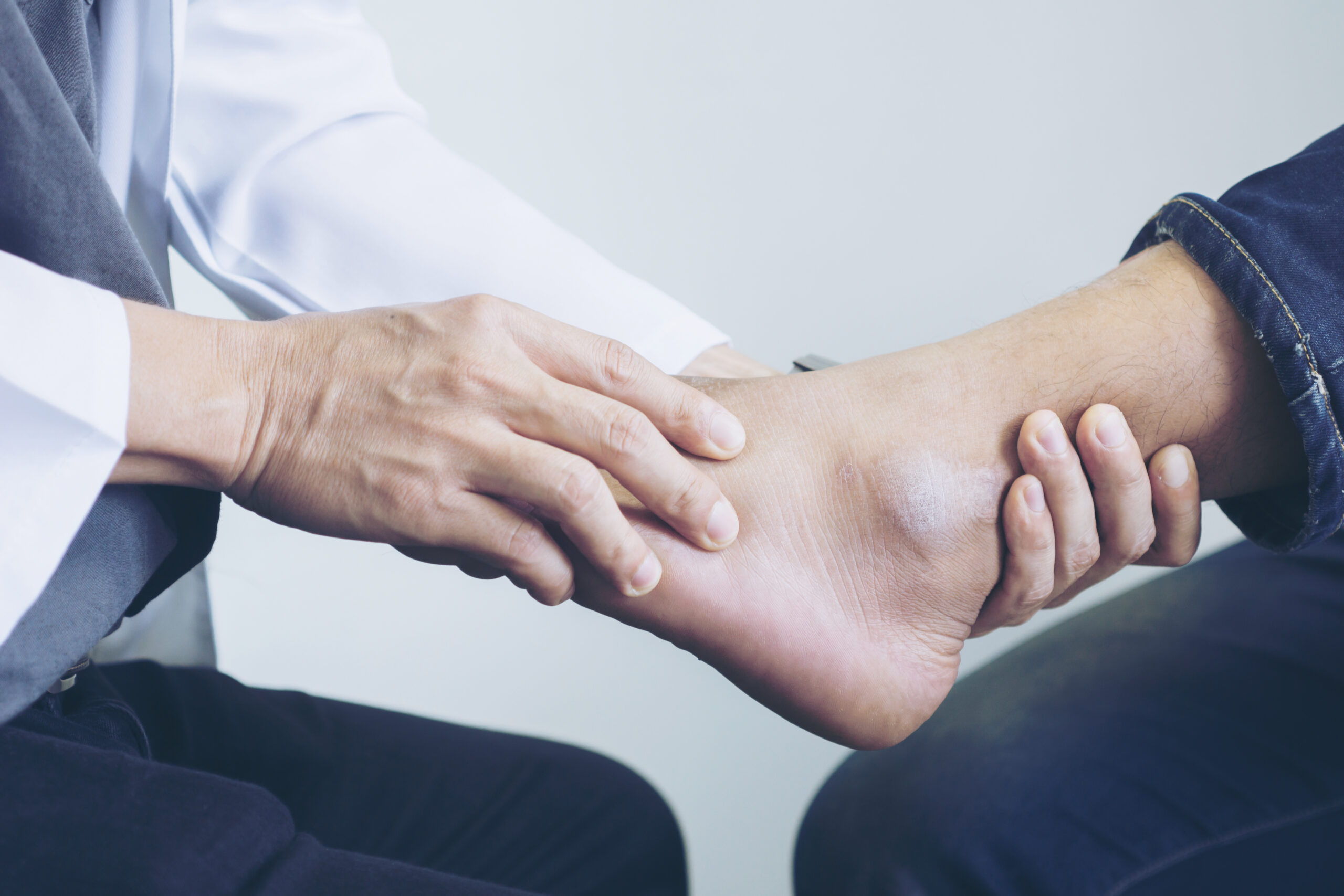 Doctor the traumatologist examines the leg examined at the medical office Doctor the traumatologist examines the leg examined at the medical office